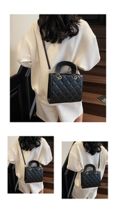 Detailed view of black quilted faux leather crossbody bag with sturdy round handles
