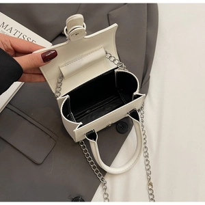 Detailed interior of a white mini handbag with silver chain strap and flap closure