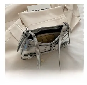 Internal capacity view of silver metallic punk shoulder bag with buckles and rivets