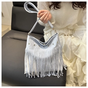 Dettaglio della borsa vintage azzurra con occhielli metallici e lunghe nappe a frangia