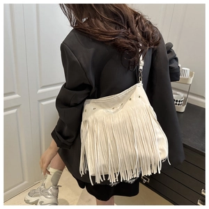Dettaglio della borsa hobo bianca con lunghe frange e rivetti metallici in pelle morbida