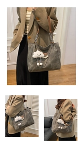 Detail of dark grey tote bag with chain strap, cloud charm, and pearl decoration