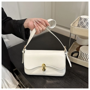 Detail of white faux leather shoulder bag featuring a prominent gold twist-lock buckle