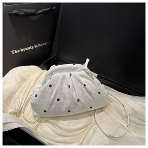 Détail de sac nuage plissé blanc avec de délicates broderies de fleurs noires stylées