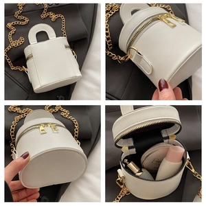 Details einer weißen Zylinder-Beuteltasche mit Innenraumansicht und goldener Kette aus PU
