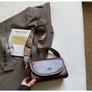 Brown faux leather crossbody bag with wide woven strap and FASHION BAGS text