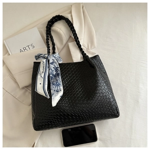 Close-up of black woven tote bag with blue silk scarf and double rope handles