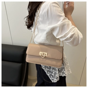 Vue détaillée du sac bandoulière en cuir beige avec chaîne dorée et fermoir en métal