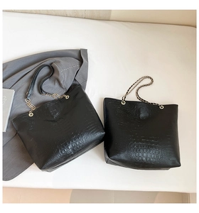 Detail of crocodile embossed leather tote bag with elegant gold chain shoulder strap