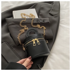 Detailansicht der schwarzen Mini-Beuteltasche mit Kontrastnaht und goldener Kette