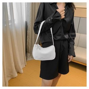Detailed side view of minimalist white underarm bag showing matte leather texture