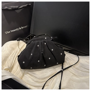 Vue détaillée d'un sac nuage noir à pois dans un coffret cadeau en soie blanche