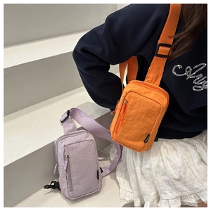 Close-up of stylish nylon chest bags in purple and orange with adjustable straps