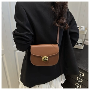 Vue arrière d'un mannequin portant le sac besace en cuir marron caramel et boucle dorée