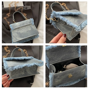 Detail view of light blue denim bag featuring fringe edges and golden metal chain strap