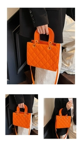 Close-up of vibrant orange quilted tote with metallic rings and adjustable strap