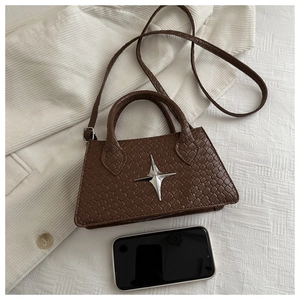 Detailed close-up of brown woven texture small square bag with silver star metal buckle