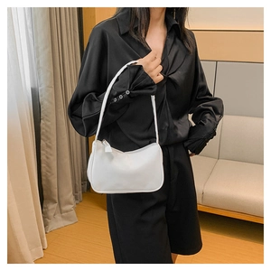 Detail of white minimalist PU leather underarm bag with zipper and thin shoulder strap