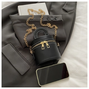 Nahaufnahme der schwarzen Mini-Eimertasche mit goldenen Zippern und weißen Nähten