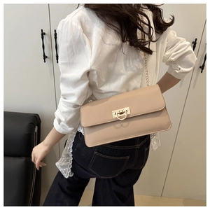 Détail d'un sac en cuir verni beige avec fermoir en D doré et fine bandoulière