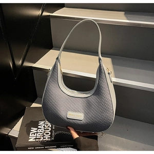 Detail of grey-blue woven fabric handbag with Miss Mini label and metal chain strap