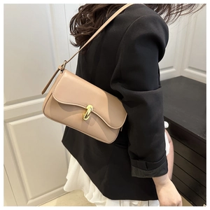 Detail of minimalist beige faux leather shoulder bag with gold twist lock on model