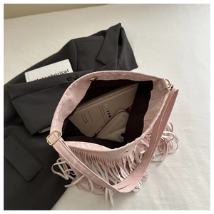 Interno della borsa a secchiello con nappe rosa che mostra spazio per taccuino e portafoglio