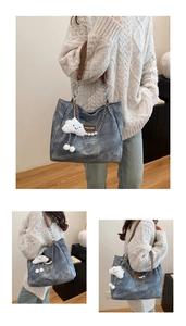 Blue tote bag with pearl chain details, metal straps and a smiling cloud plush pendant