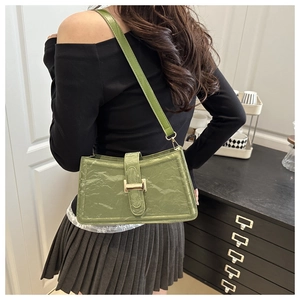 Modern olive green baguette shoulder bag with pleated texture and gold buckle shown on model
