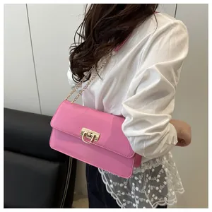 Detailed side view of pink leather bag with golden U-shaped lock and metal chain strap