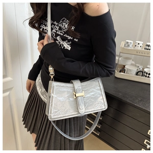 Detail of silver metallic baguette bag featuring a gold H-clasp and wrinkled leather texture