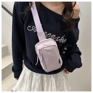 Detail of light purple nylon crossbody bag with adjustable strap and dual zipper pockets