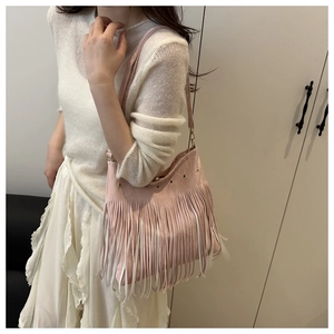 Dettaglio borsa shopper rosa con nappe, occhielli in metallo e stile boho chic