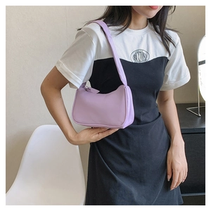 Detail of a purple leather hobo bag with smooth finish and minimalist half-moon design