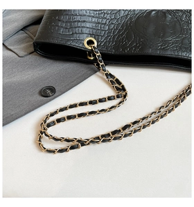 Close-up of black crocodile texture tote bag with elegant gold metal chain strap