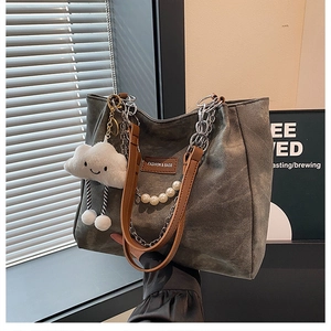 Detail of grey tote bag with silver chain, pearl strap and white cloud charm