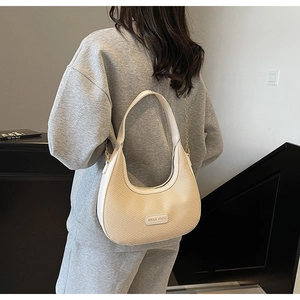 Detail of beige woven half-moon bag featuring Miss mini leather tag and gold chain strap