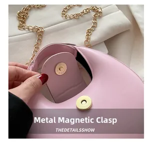Détail du sac demi-lune rose avec fermeture magnétique dorée sécurisée et bandoulière chaîne