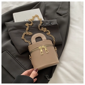 Detailansicht der mokkabraunen Leder-Eimertasche mit Doppelreißverschluss und Goldkette