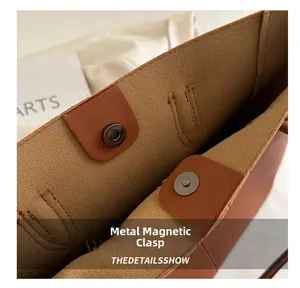 Detail shot of the secure magnetic snap closures on the brown leather tote bag