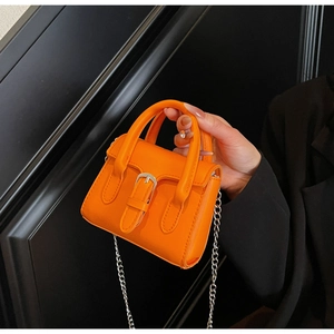 Detail of a bright orange mini square bag with silver chain strap and metal buckle