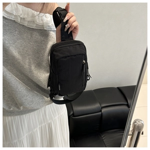 Detailansicht der schwarzen Nylon-Brusttasche mit verstellbarem Gurt und Reißverschlüssen
