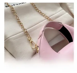 Détail du sac à main en cuir rose avec crochet en métal doré et bandoulière en chaîne