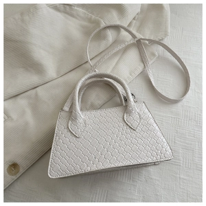 Detail of cream white woven leather handbag texture with top handles and shoulder strap