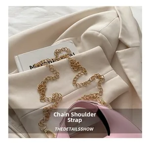 Détail du sac à bandoulière rose avec chaîne dorée posé sur un blazer beige chic