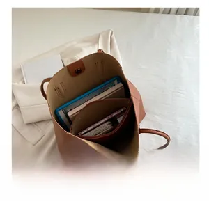 Close-up showing the large capacity and inner pouch of this brown faux leather tote bag