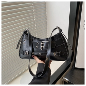 Detail of black faux leather shoulder bag with punk metal buckles and silver rivets
