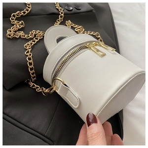 Detail der weißen Mini-Eimertasche aus Leder mit goldener Kette und Reißverschluss