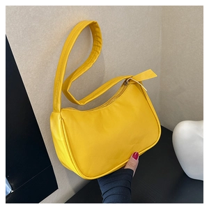 Detail of bright yellow underarm bag with zipper closure and smooth water-resistant finish