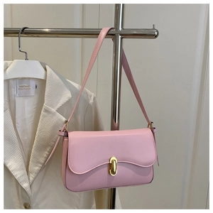 Pink faux leather baguette bag with gold twist lock worn over white corduroy blazer